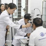 Các bác sỹ Đoàn Y tế tỉnh Vân Nam, Trung Quốc thăm khám cho bệnh nhân trước khi phẫu thuật. (Ảnh: Xuân Tư/TTXVN)