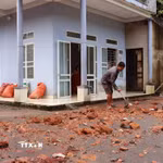 Người dân tranh thủ dọn dẹp đất đá, bùn đất để sớm khôi phục sinh hoạt. (Ảnh: Đức Thọ/TTXVN)