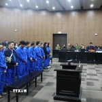 Các bị cáo nghe đại diện Viện kiểm sát đọc bản cáo trạng. (Ảnh: Quốc Lũy/TTXVN)