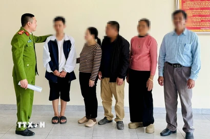 Công an phường Phú Bài (Công an thành phố Huế) bàn giao nạn nhân cho gia đình. (Ảnh: TTXVN phát)