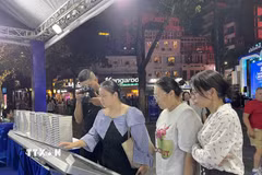 khách tham quan, trải nghiệm tại không gian "Sách mở tri thức - Công nghệ dẫn tương lai.” (Ảnh: Tuyết Mai/TTXVN)