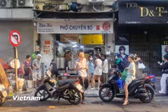 Hàng dài người xếp hàng chờ đến lượt tại một quán phở vào sáng sớm. (Nguồn: Vietnam+)
