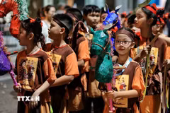 Các em nhỏ tham gia đoàn rước với những mô hình ngựa giấy nhiều màu sắc, tái hiện nét vui chơi dân gian trong đêm Trung thu giữa lòng Hà Nội. (Ảnh: Phạm Tuấn Anh/TTXVN)