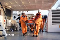 Vận chuyển bệnh nhân người nước ngoài lên bờ để đưa đi cứu chữa. (Ảnh: TTXVN phát)