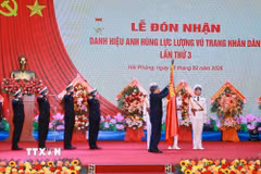 Tổng Bí thư Tô Lâm, Bí thư Quân ủy Trung gắn Huy hiệu Anh hùng Lực lượng Vũ trang nhân dân lên Quân kỳ Quyết thắng của Quân chủng Hải quân. (Ảnh: Trọng Đức/TTXVN)