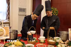 Quan chức ngoại giao tại Trung Quốc trải nghiệm cách chế biến một tô phở. (Ảnh: Hải Yến/TTXVN)