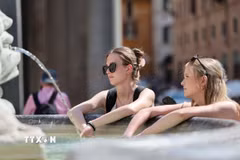 Người dân tránh nóng bên đài phun nước ở Rome, Italy ngày 26/5/2026. (Ảnh: THX/TTXVN)