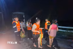Người dân được cứu an toàn khi mắc kẹt giữa dòng nước lũ tại Suối Cái. (Ảnh: TTXVN phát)
