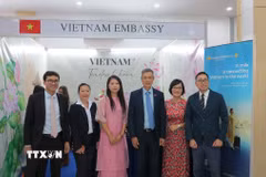 Đại sứ Nguyễn Minh Vũ (thứ ba từ phải sang) chụp ảnh lưu niệm cùng các nhân viên sứ quán và doanh nghiệp tại gian trưng bày của Việt Nam. (Ảnh: Minh Hưng/TTXVN)