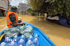 Lực lượng quân đội vận chuyển nước uống tới khu vực bị mưa lũ cô lập. (Ảnh: Quang Duy/TTXVN)