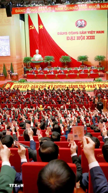 Các đại biểu biểu quyết, thông qua Nghị quyết Đại hội XIII Đảng Cộng sản Việt Nam. (Ảnh: TTXVN)