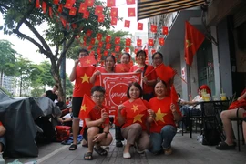 Chị Nguyễn Thị Hường cùng đoàn 20 người từ Hải Phòng và Hưng Yên (Thái Bình cũ) hào hứng cho biết đã sắp xếp công việc để đến Hà Nội từ hơn 14 giờ chiều, sẵn sàng chờ khoảng 16 tiếng qua đêm. (Ảnh: Minh Anh/Vietnam+)