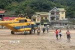 Máy bay trực thăng Mi 171 của Quân chủng Phòng không Không quân mang theo hàng cứu trợ gồm lương thực, thực phẩm, nước uống... hạ cánh xuống huyện Tương Dương. (Ảnh: TTXVN phát)