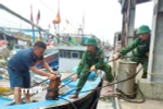 Lực lượng Bộ đội biên phòng tỉnh Nghệ An hỗ trợ giúp ngư dân chằng néo tàu thuyền tại nơi tránh trú bão an toàn. (Ảnh: TTXVN phát)