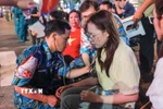 Bác sỹ quân y hỗ trợ kiểm tra sức khoẻ cho người dân bị tụt huyết áp, khó thở khi chờ đợi lâu trong đám đông và thời tiết không thuận lợi trong đêm 29, rạng sáng 30/8. (Ảnh: Hoàng Hiếu/TTXVN)