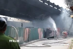 Lực lượng Cảnh sát Phòng cháy chữa cháy nỗ lực kiểm soát đám cháy tại bãi trông giữ xe dưới gầm cầu Vĩnh Tuy. (Ảnh: Vũ Quang/TTXVN)