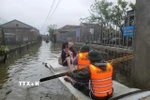 Bộ đội Biên phòng Hà Tĩnh hỗ trợ di dời người dân ra khỏi vùng ngập lụt. (Ảnh: Hoàng Ngà/TTXVN)