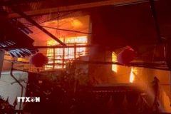 Ngọn lửa bao trùm tầng hai của ngôi nhà. (Ảnh: TTXVN)