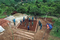 Các lực lượng tích cực tham gia xây dựng nhà ở cho nhân dân bị ảnh hưởng, thiệt hại do lũ quét, sạt lở đất trên địa bàn xã Huổi Một. (Ảnh: Quang Quyết/TTXVN)