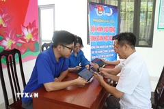Lực lượng đoàn thanh niên cơ sở tích cực hỗ trợ người dân thực hiện "Bình dân học vụ số". (Ảnh: Nguyễn Cúc/TTXVN)