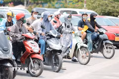 Khẩu trang, áo chống nắng là những thứ không thể thiếu của người dân khi tham gia giao thông. (Ảnh: Lê Đông/TTXVN)