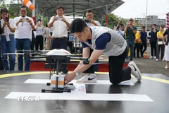 Nhân viên chuẩn bị gói hàng để vận chuyển bằng UAV. (Ảnh: Thu Hoài/TTXVN)
