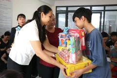 Trao quà tết cho các em khuyết tật và hoàn cảnh khó khăn. (Ảnh: Phúc Sơn/TTXVN)