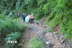 Người dân trong bản Na Ngân thường di chuyển trên con đường đất độc đạo để ra khu vực vùng ngoài. (Ảnh: Xuân Tiến/TTXVN)