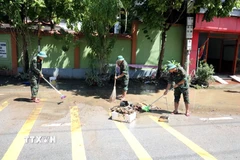 Các cán bộ chiến sỹ Bộ Chỉ huy Quân sự tỉnh Lạng Sơn giúp người dân Thất Khê dọn dẹp vệ sinh. (Ảnh: Văn Đạt/TTXVN)