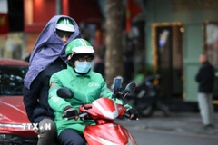 Người dân che chắn chống rét khi phải di chuyển trên đường. (Ảnh: Hoàng Hiếu/TTXVN)