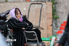 Một người bán hàng co ro trong tiết trời lạnh. (Ảnh: Hoàng Hiếu/TTXVN)