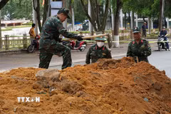 Lực lượng chức năng tiến hành đào rãnh thăm dò dọc đường Trường Chinh (Quảng Ngãi). (Ảnh: Dư Toán/TTXVN)