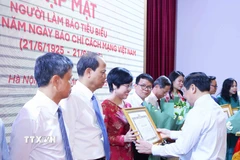 Đồng chí Lại Xuân Môn, Ủy viên Trung ương Đảng, Phó Trưởng Ban Thường trực Ban Tuyên giáo và Dân vận Trung ương trao Bằng khen cho nhà báo Ninh Hồng Nga, Tổng Biên tập Báo Tin tức và Dân tộc (TTXVN). (Ảnh: Phương Hoa/TTXVN)