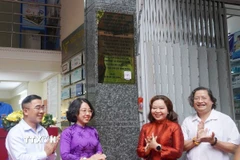 Các đại biểu thực hiện nghi thức ra mắt bảng hiệu Di tích Lịch sử cấp Quốc gia Trụ sở báo Dân Chúng. (Ảnh: Thu Hương/TTXVN)