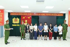 Cơ quan cảnh sát điều tra thi hành lệnh bắt tạm giam các bị can. (Ảnh: TTXVN phát)