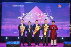 Phó Chủ tịch thường trực UBND thành phố Huế Nguyễn Thanh Bình tặng hoa cho các đại diện Hàn Quốc tham gia ngày hội. (Ảnh: Mai Trang/TTXVN)