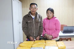 Hai đối tượng Mùa A Cú và Thào Thị Ly cùng tang vật tại cơ quan Công an. (Ảnh: TTXVN phát)