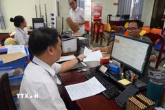 Giải quyết hồ sơ, thủ tục hành chính cho người dân và doanh nghiệp tại Trung tâm phục vụ hành chính công phường Rạch Giá (An Giang). (Ảnh: Lê Huy Hải/TTXVN)