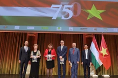 Đại sứ Bùi Lê Thái trao tặng cho các khách mời danh dự Tập san đặc biệt do Đại sứ quán Việt Nam tại Hungary phối hợp với Tạp chí Eurasia xuất bản nhân kỷ niệm 75 năm thiết lập quan hệ ngoại giao giữa hai nước. (Ảnh: TTXVN)