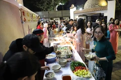 Bà con cộng đồng người Việt tại Ai Cập và bạn bè quốc tế thưởng thức các món ăn truyền thống của Việt Nam. (Ảnh: Nguyễn Trường/TTXVN)