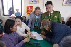 Người dân kí nhận, làm thủ tục để nhận quà của Đảng và Nhà nước. (Ảnh: Thanh Thuỷ/TTXVN)