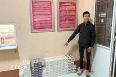 Đối tượng vận chuyển thuốc lá lậu khuya ngày 26/3/2026 bị bắt giữ cùng tang vật. (Ảnh: TTXVN phát)