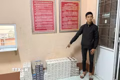 Đối tượng vận chuyển thuốc lá lậu khuya ngày 26/3/2026 bị bắt giữ cùng tang vật. (Ảnh: TTXVN phát)