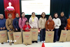 Cán bộ, nhân viên Văn phòng TTXVN với các gia đình được nhận quà tặng. (Ảnh: Quang Cường/TTXVN)
