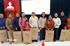 Cán bộ, nhân viên Văn phòng TTXVN với các gia đình được nhận quà tặng. (Ảnh: Quang Cường/TTXVN)