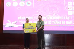 Trao bảng tượng trưng kinh phí hỗ trợ tập cho học sinh. (Ảnh: Lê Thúy Hằng/TTXVN)