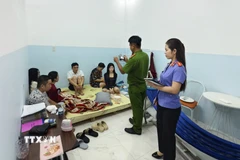 Nhóm đối tượng bị bắt quả tang sử dụng ma túy tại tầng trệt. (Ảnh: TTXVN phát)