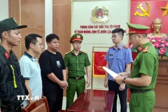 Cơ quan điều tra tống đạt Quyết định tố tụng đối với Huang HuiGuang. (Nguồn: TTXVN)