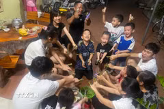 Người lớn, trẻ em cùng nhuộm móng tay trong đêm trước ngày Tết Đoan Ngọ. (Ảnh: TTXVN phát)
