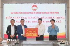 Đại diện Thường trực Đảng ủy và Ủy ban Mặt trận Tổ quốc Việt Nam xã Tân An (bên trái) chuyển tới Mặt trận Tổ quốc Việt Nam thành phố Hải Phòng 150 triệu đồng do nhân dân xã Tân An đóng góp, để ủng hộ đồng bào miền Trung - Tây Nguyên. (Ảnh: Mạnh Minh/TTXVN)